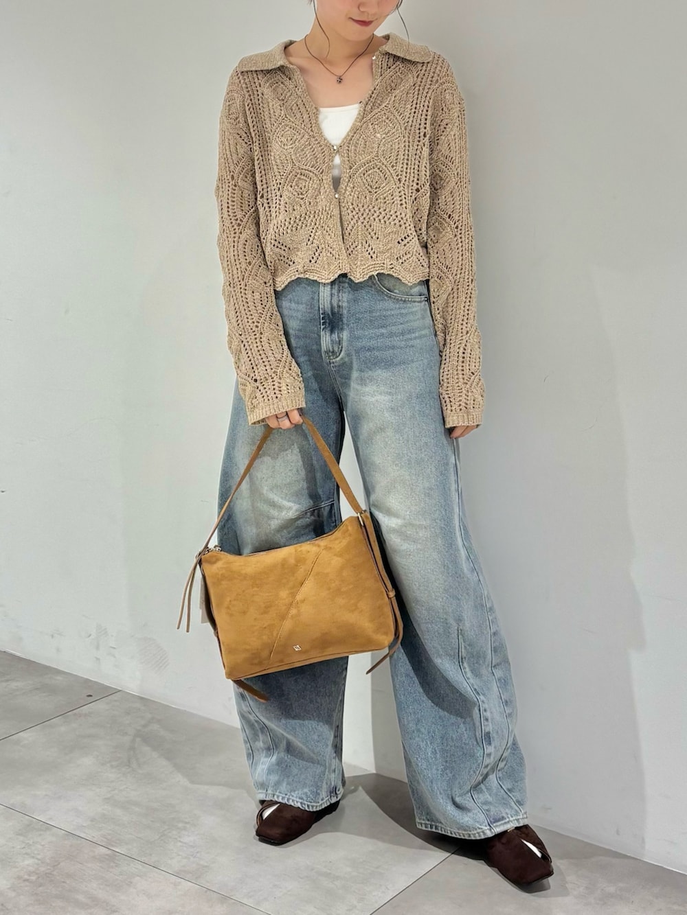 ブルー系のデニムパンツ、ブラウン系のパンプス、イエロー系のショルダーバッグを着用したレディースの秋コーディネートの3枚目の写真