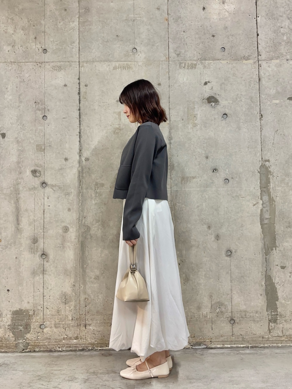 ホワイト系のシャツ/ブラウス、グレー系のニット/セーター、ホワイト系のスカートを着用したレディースの春コーディネートの3枚目の写真