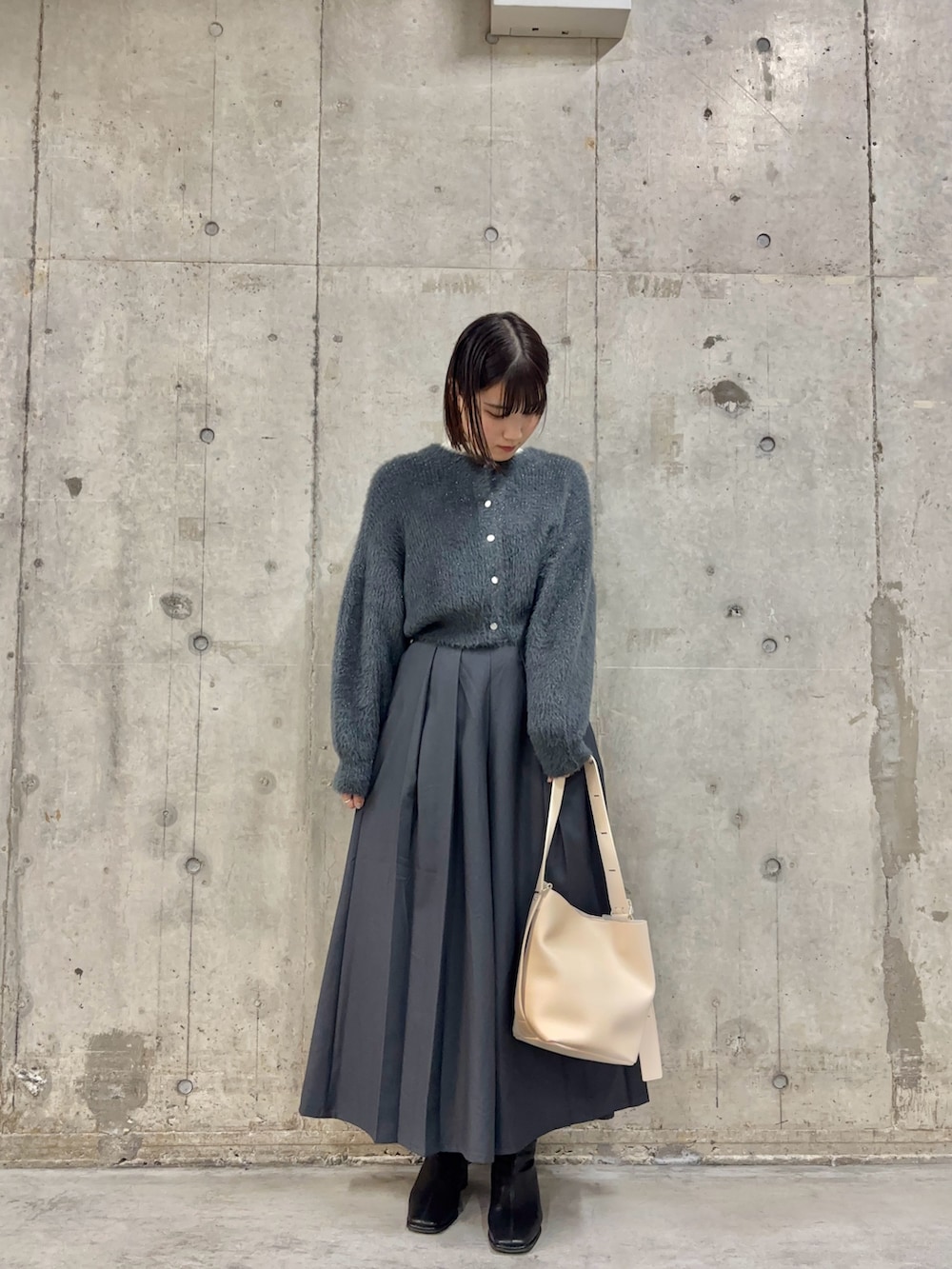 ホワイト系のTシャツ/カットソー、グレー系のカーディガン/ボレロ、ベージュ系のショルダーバッグを着用したレディースの冬コーディネートの2枚目の写真