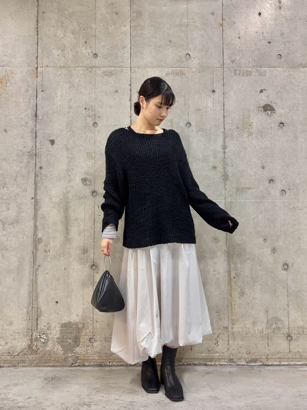 ブラック系のブーツ、ホワイト系のスカート、ホワイト系のTシャツ/カットソーを着用したレディースの冬コーディネートの2枚目の写真