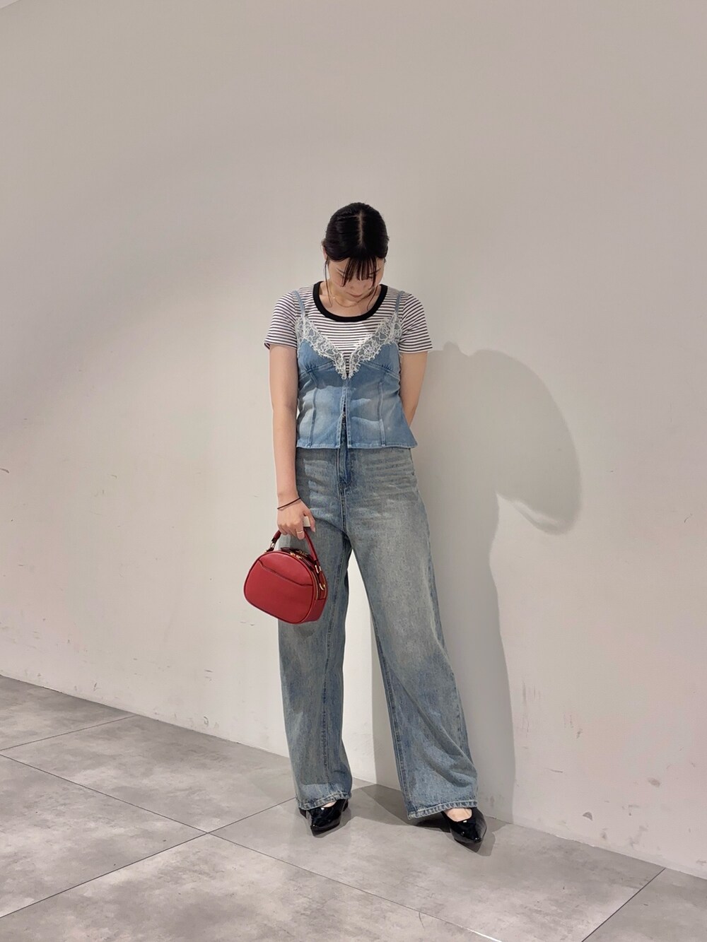 ブルー系のデニムパンツ、ホワイト系のTシャツ/カットソー、ブルー系のキャミソールを着用したレディースの夏コーディネートの2枚目の写真
