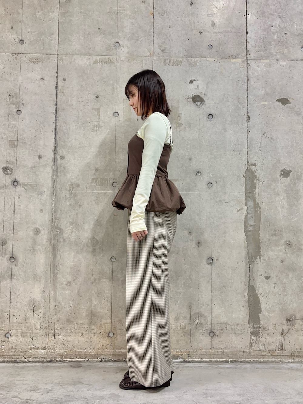 ベージュ系のスラックス、ブラウン系のローファー、イエロー系のTシャツ/カットソーを着用したレディースの春コーディネートの3枚目の写真