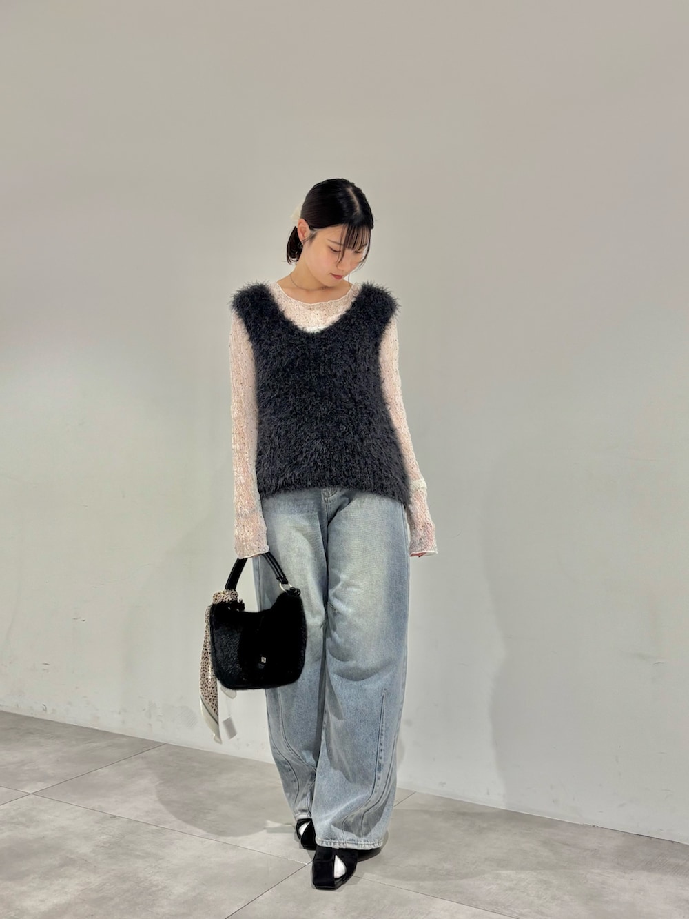 グレー系のベスト、ホワイト系のTシャツ/カットソー、ブラック系のパンプスを着用したレディースの秋コーディネートの2枚目の写真