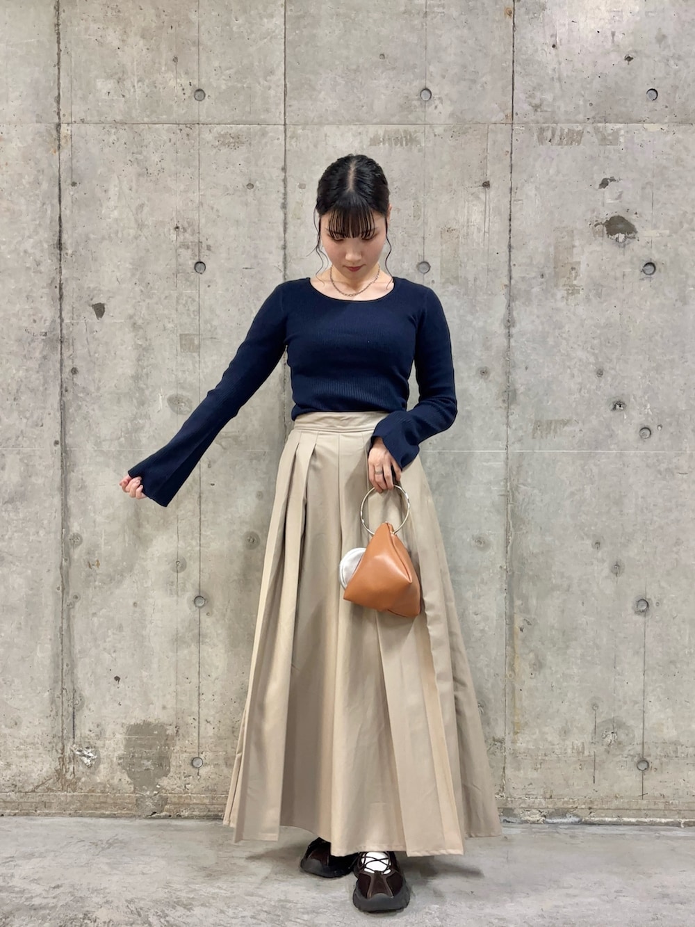 ブルー系のニット/セーター、ベージュ系のその他パンツ、イエロー系のハンドバッグを着用したレディースの秋コーディネートの2枚目の写真