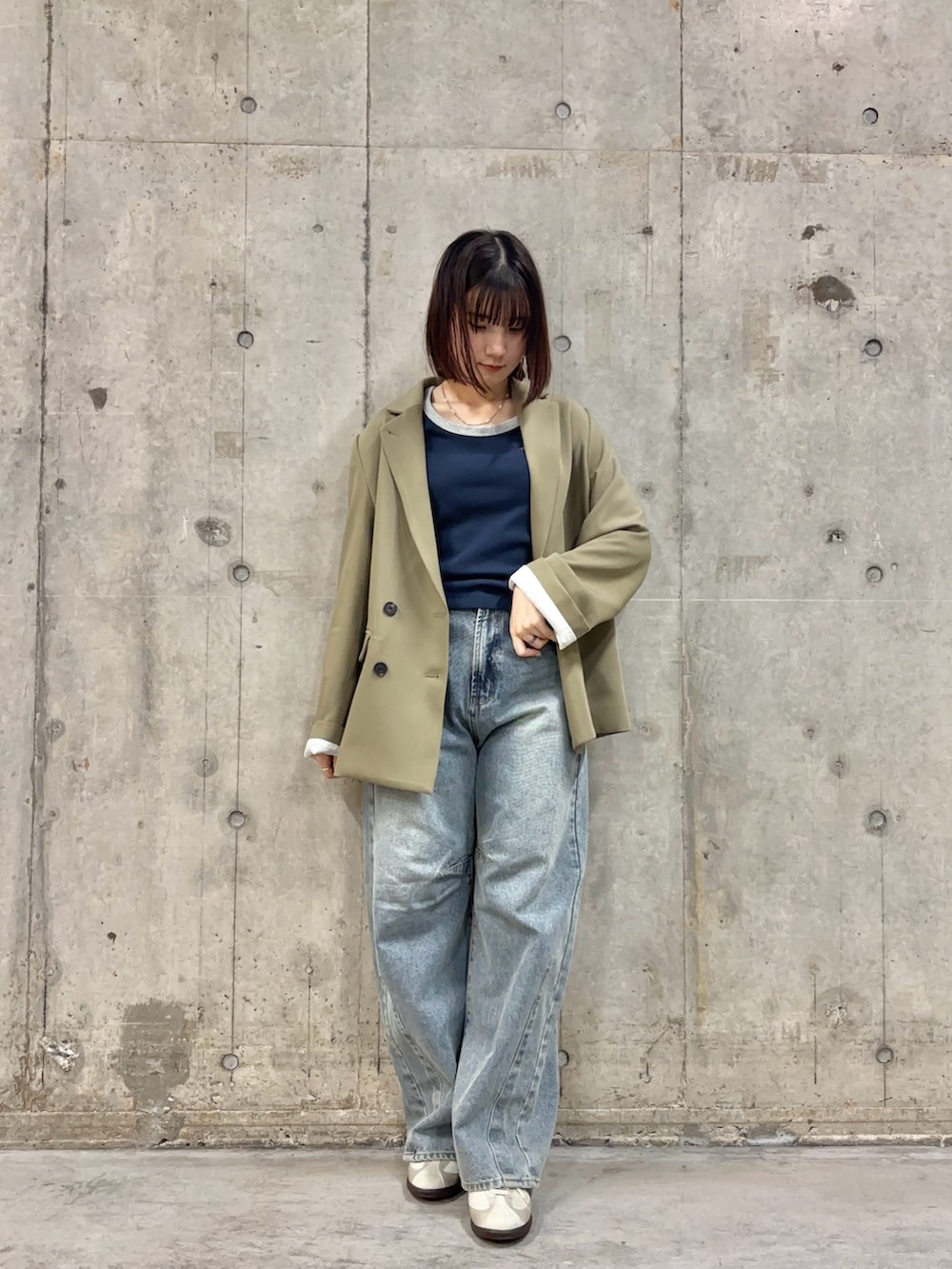 ベージュ系のテーラードジャケット、ブルー系のTシャツ/カットソー、ブルー系のデニムパンツを着用したレディースの冬コーディネートの2枚目の写真