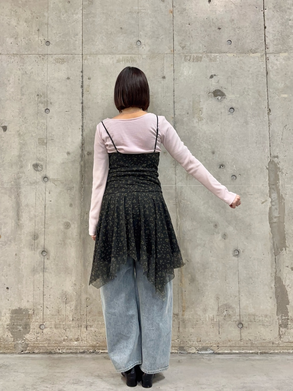 ブラック系のワンピース、ピンク系のTシャツ/カットソー、ブルー系のデニムパンツを着用したレディースの春コーディネートの4枚目の写真