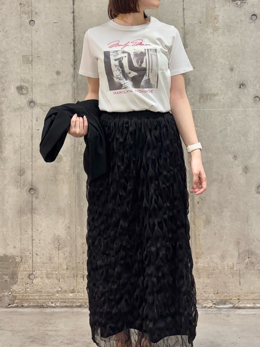 ブラック系のスカート、ブラック系のその他アウター、その他のTシャツ/カットソーを着用したレディースの春コーディネートの3枚目の写真