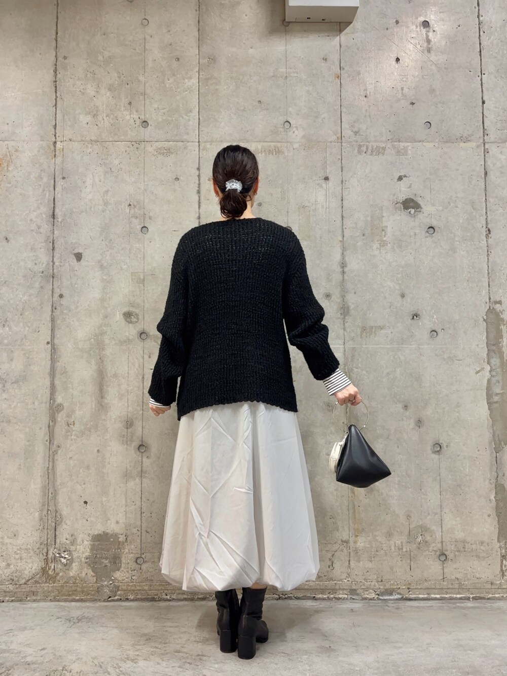 ブラック系のブーツ、ホワイト系のスカート、ホワイト系のTシャツ/カットソーを着用したレディースの冬コーディネートの4枚目の写真