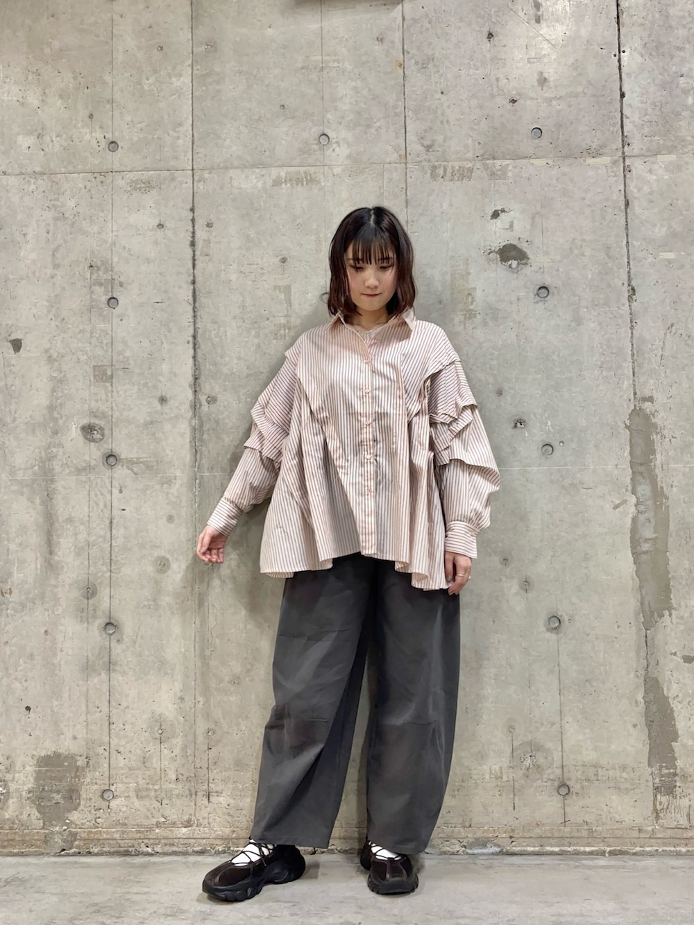 グレー系のその他パンツ、ブラウン系のスニーカー、ピンク系のシャツ/ブラウスを着用したレディースの冬コーディネートの4枚目の写真