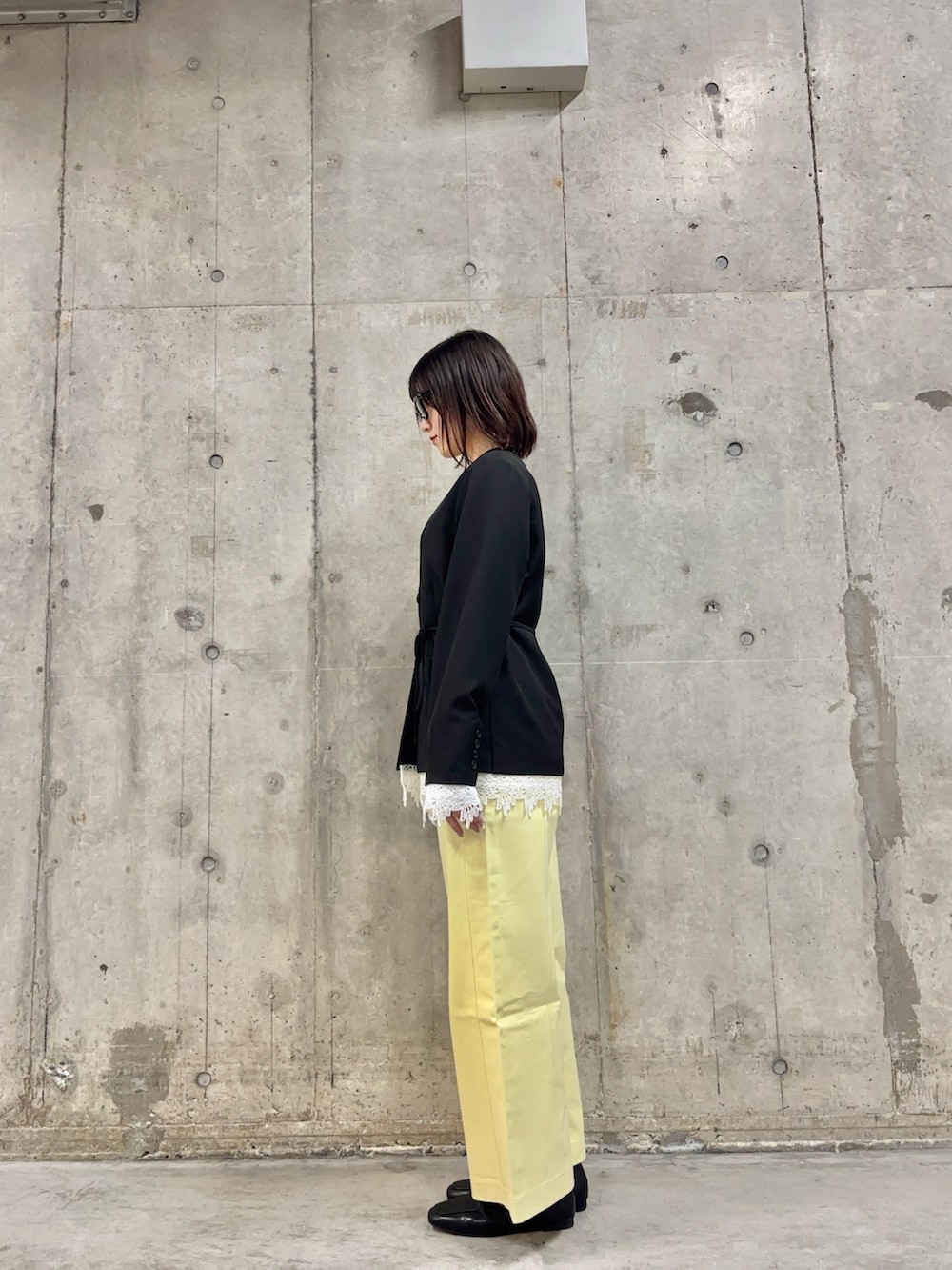 ブラック系のノーカラージャケット、ホワイト系のTシャツ/カットソー、イエロー系のその他パンツを着用したレディースの春コーディネートの3枚目の写真