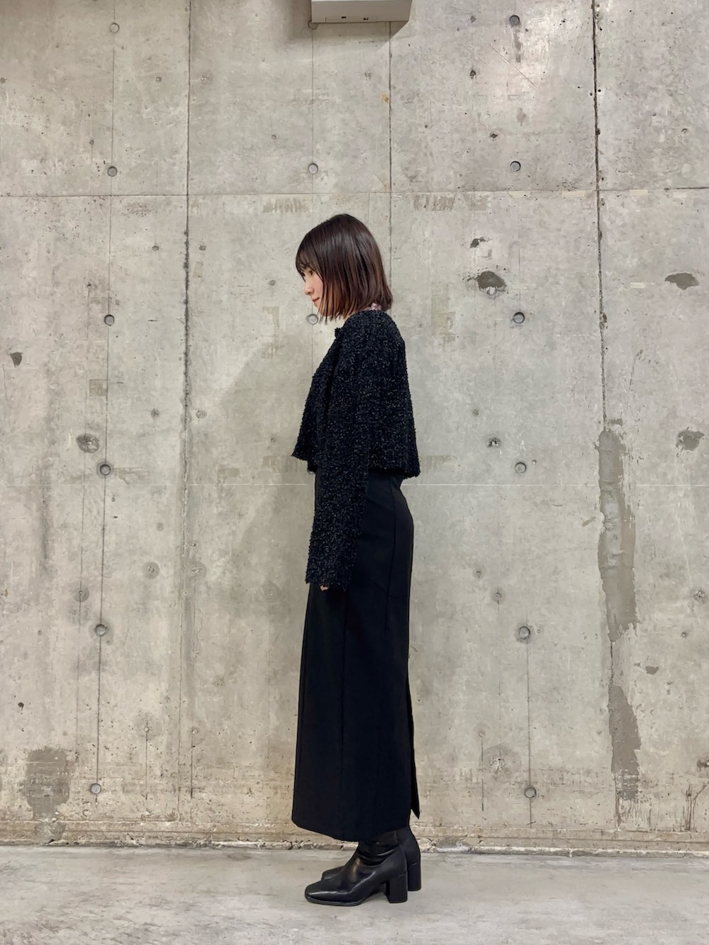 ブラック系のスカート、ピンク系のTシャツ/カットソー、ブラック系のブーツを着用したレディースの冬コーディネートの3枚目の写真