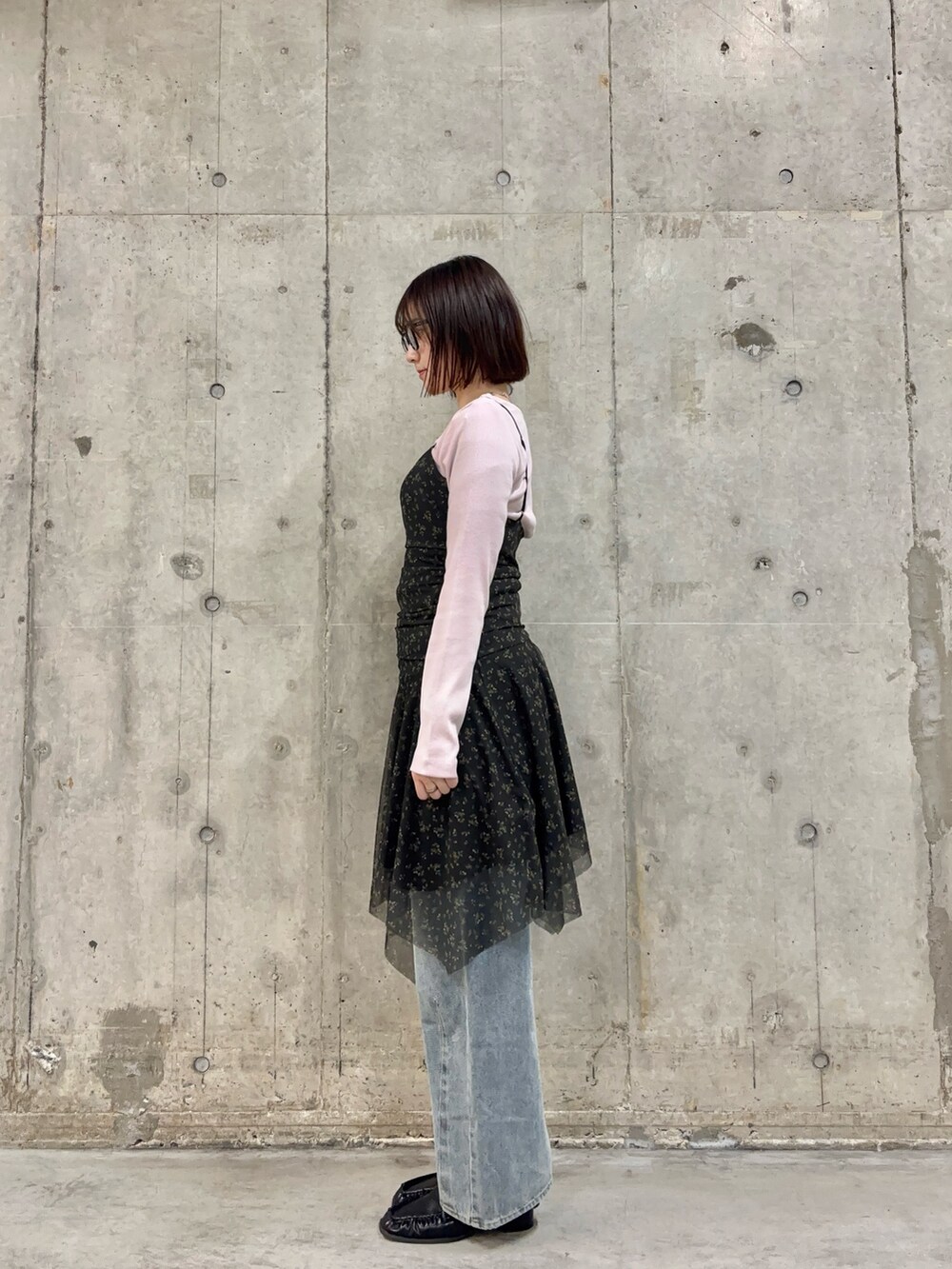 ブラック系のワンピース、ピンク系のTシャツ/カットソー、ブルー系のデニムパンツを着用したレディースの春コーディネートの3枚目の写真