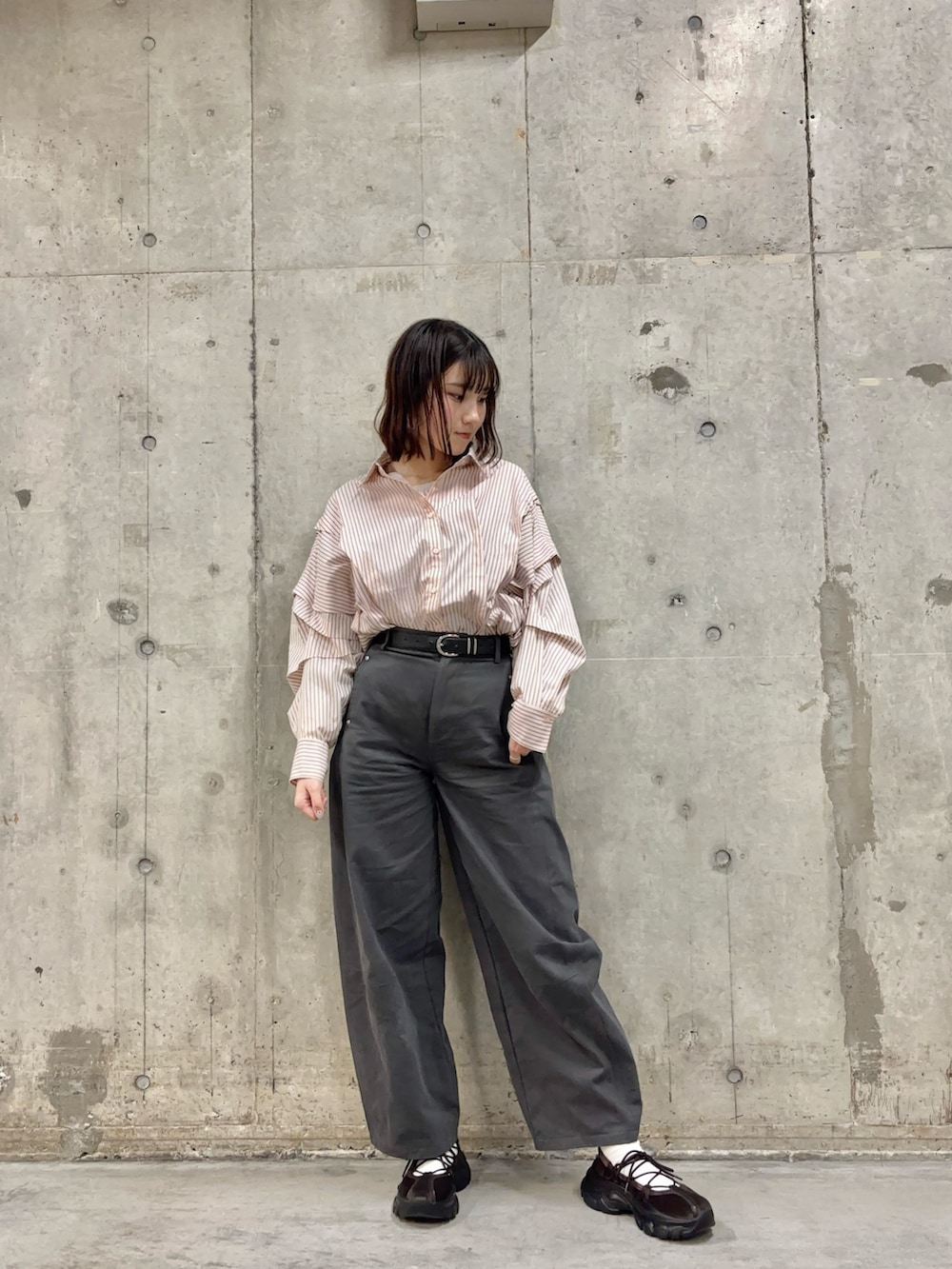 グレー系のその他パンツ、ブラウン系のスニーカー、ピンク系のシャツ/ブラウスを着用したレディースの冬コーディネートの2枚目の写真