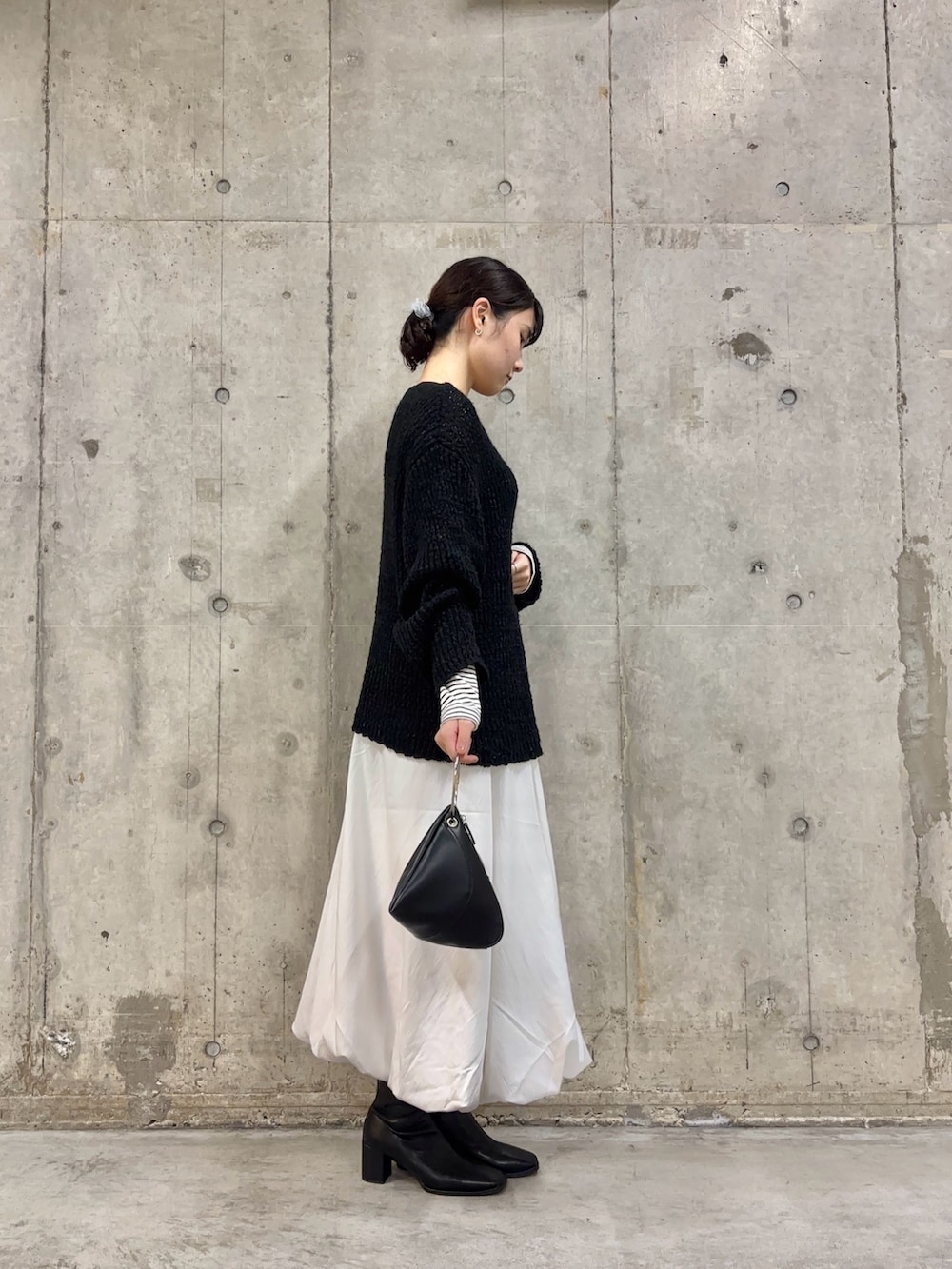 ブラック系のブーツ、ホワイト系のスカート、ホワイト系のTシャツ/カットソーを着用したレディースの冬コーディネートの3枚目の写真
