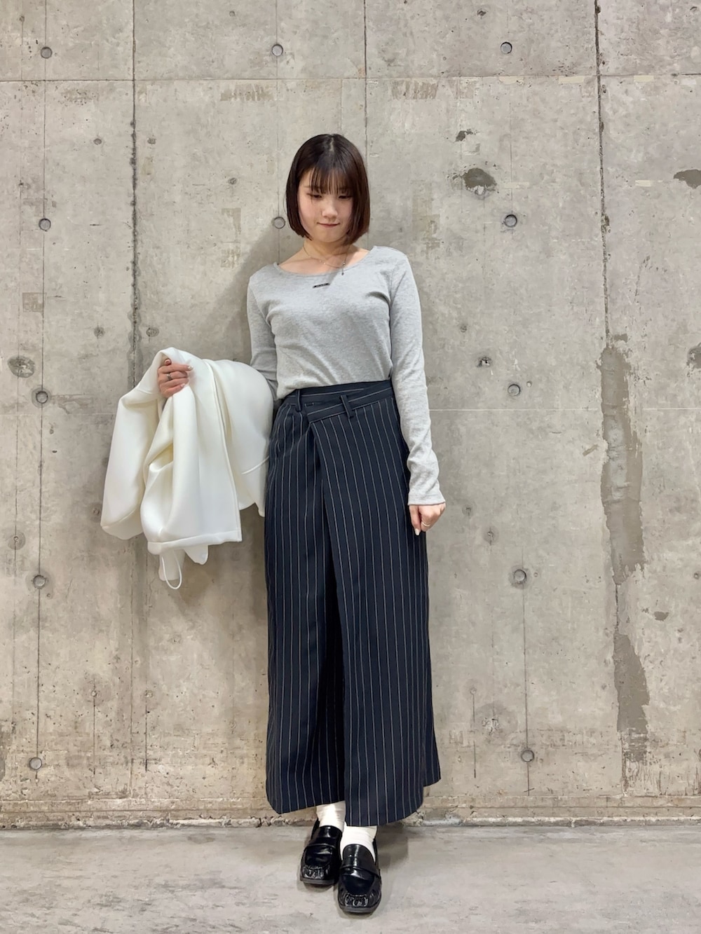 ホワイト系のパーカー、グレー系のTシャツ/カットソー、ブルー系のスカートを着用したレディースの春コーディネートの2枚目の写真