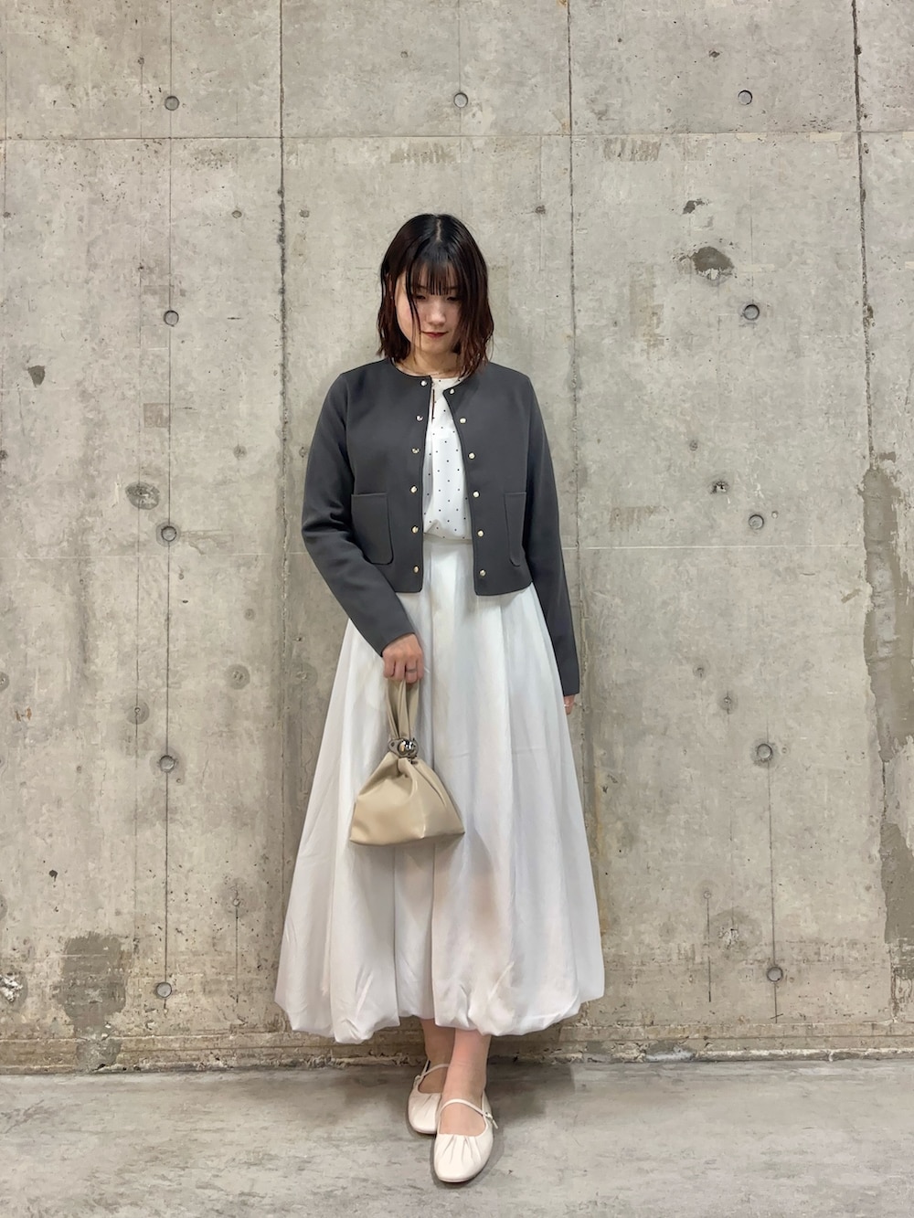 ホワイト系のシャツ/ブラウス、グレー系のニット/セーター、ホワイト系のスカートを着用したレディースの春コーディネートの2枚目の写真