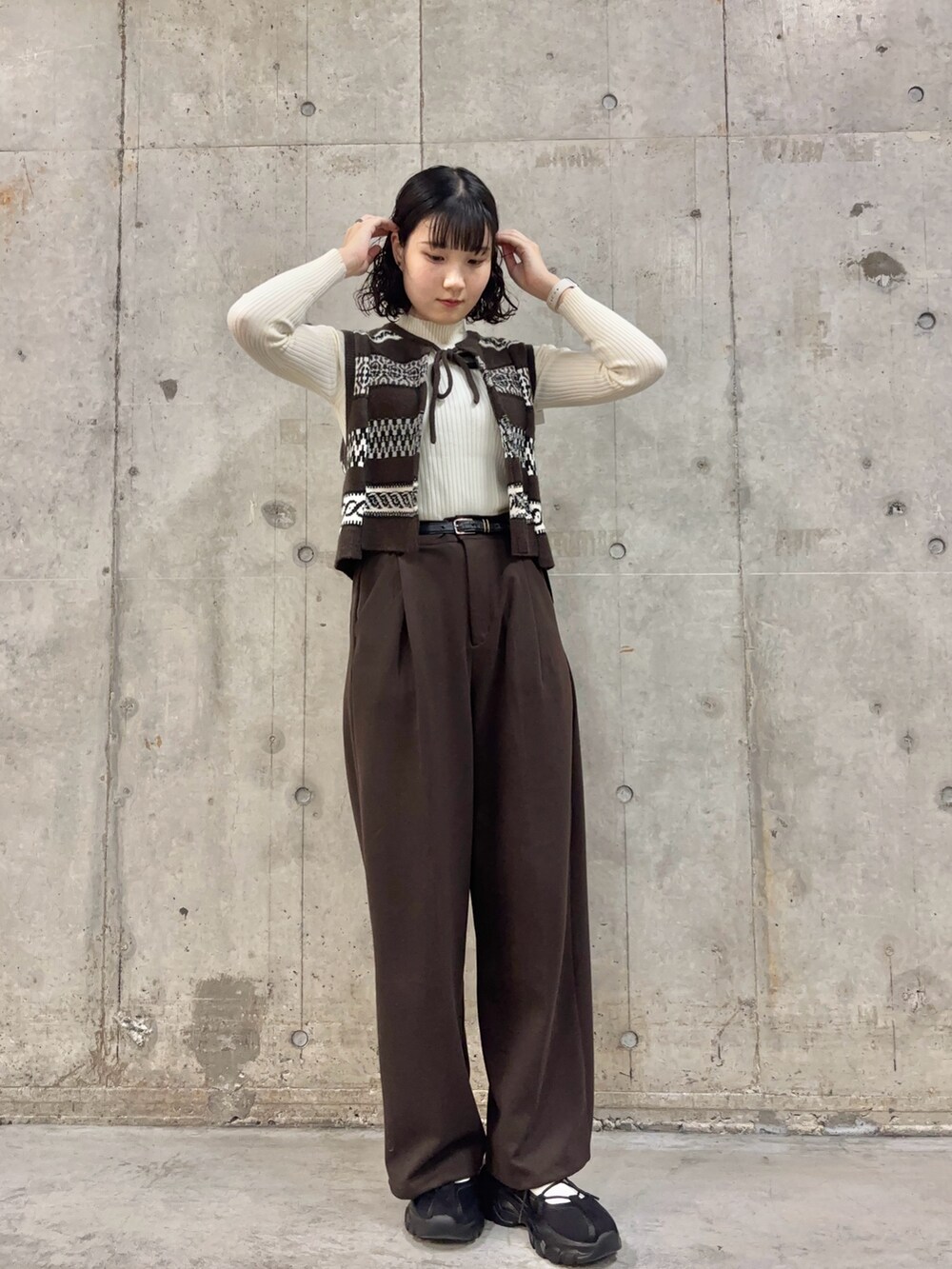 ブラウン系のその他パンツ、ブラウン系のベスト、ホワイト系のニット/セーターを着用したレディースの秋コーディネートの3枚目の写真