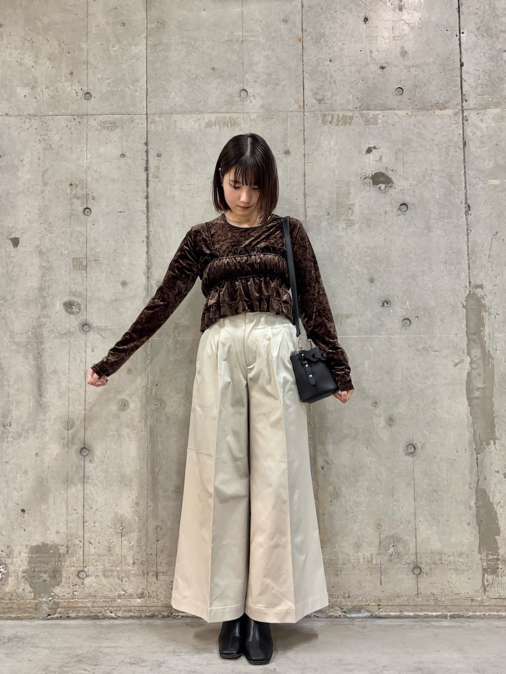 ブラック系のブーツ、ホワイト系のチノパンツ、ブラウン系のTシャツ/カットソーを着用したレディースの冬コーディネートの2枚目の写真