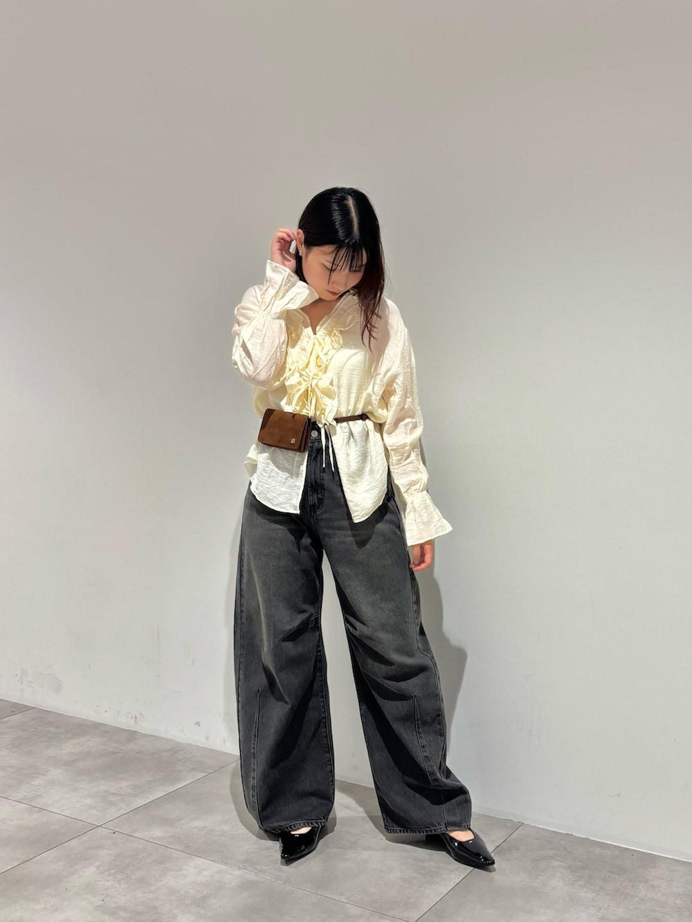 グレー系のデニムパンツ、ホワイト系のシャツ/ブラウス、ブラック系のパンプスを着用したレディースの秋コーディネートの2枚目の写真