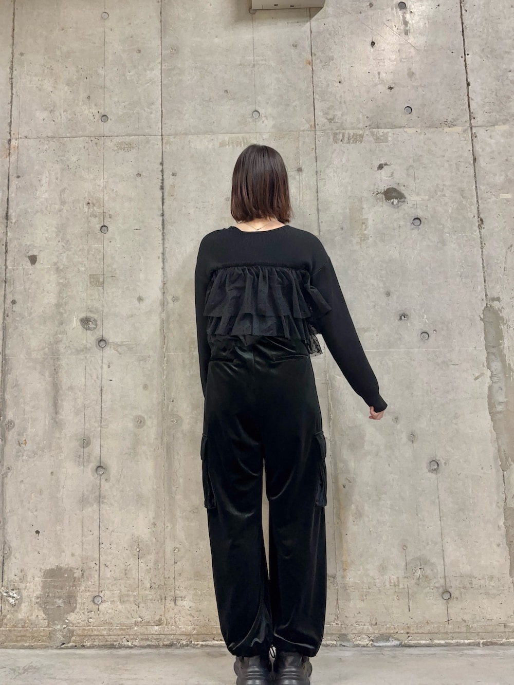 ブラック系のその他パンツ、ブラック系のニット/セーター、ブラック系のスニーカーを着用したレディースの冬コーディネートの4枚目の写真