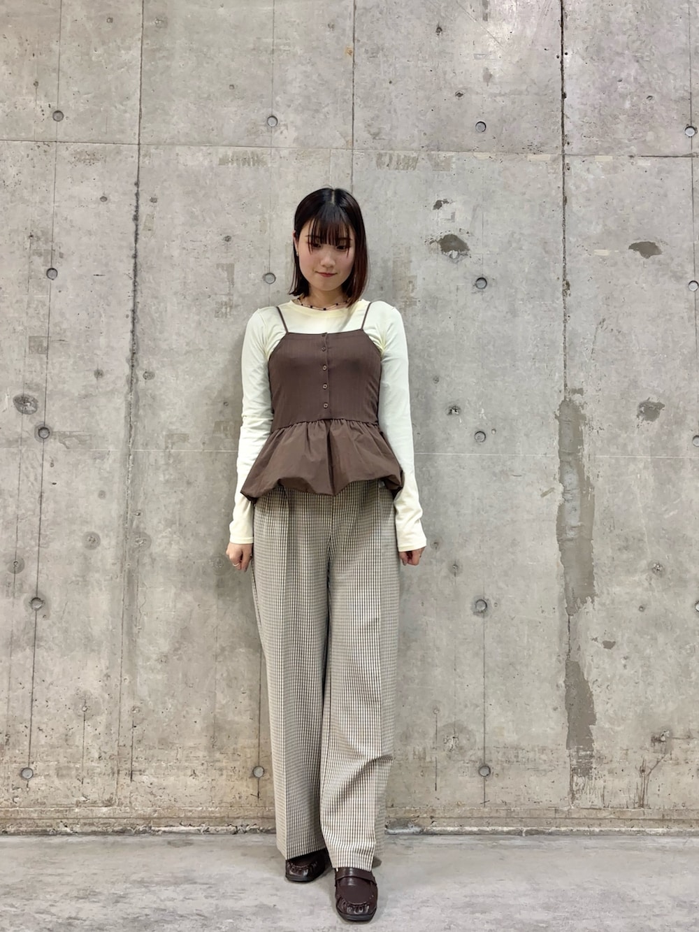 ベージュ系のスラックス、ブラウン系のローファー、イエロー系のTシャツ/カットソーを着用したレディースの春コーディネートの2枚目の写真