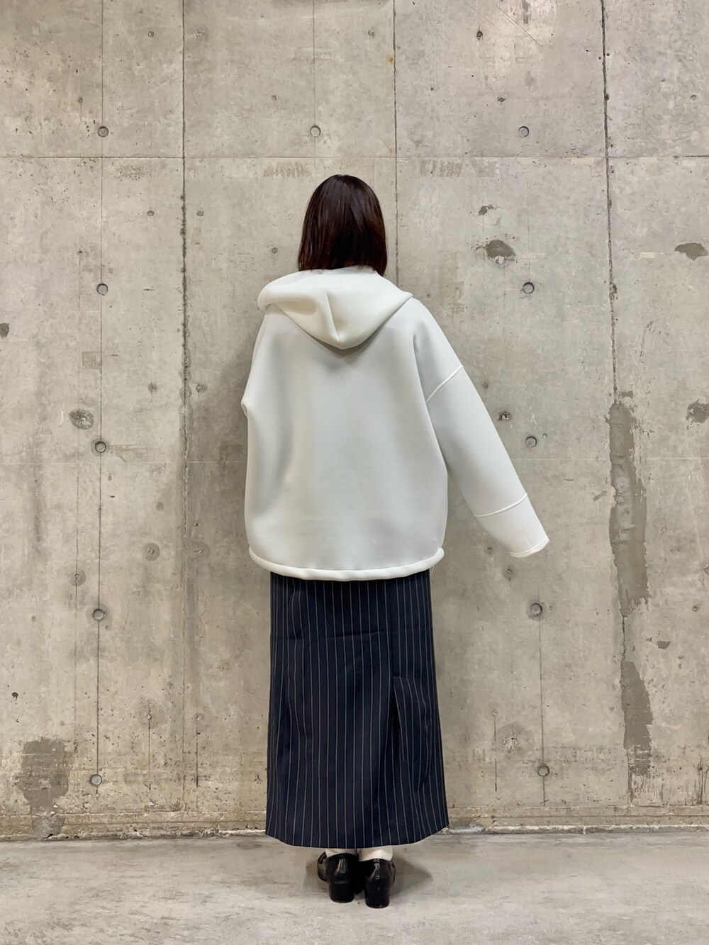 ホワイト系のパーカー、グレー系のTシャツ/カットソー、ブルー系のスカートを着用したレディースの春コーディネートの3枚目の写真