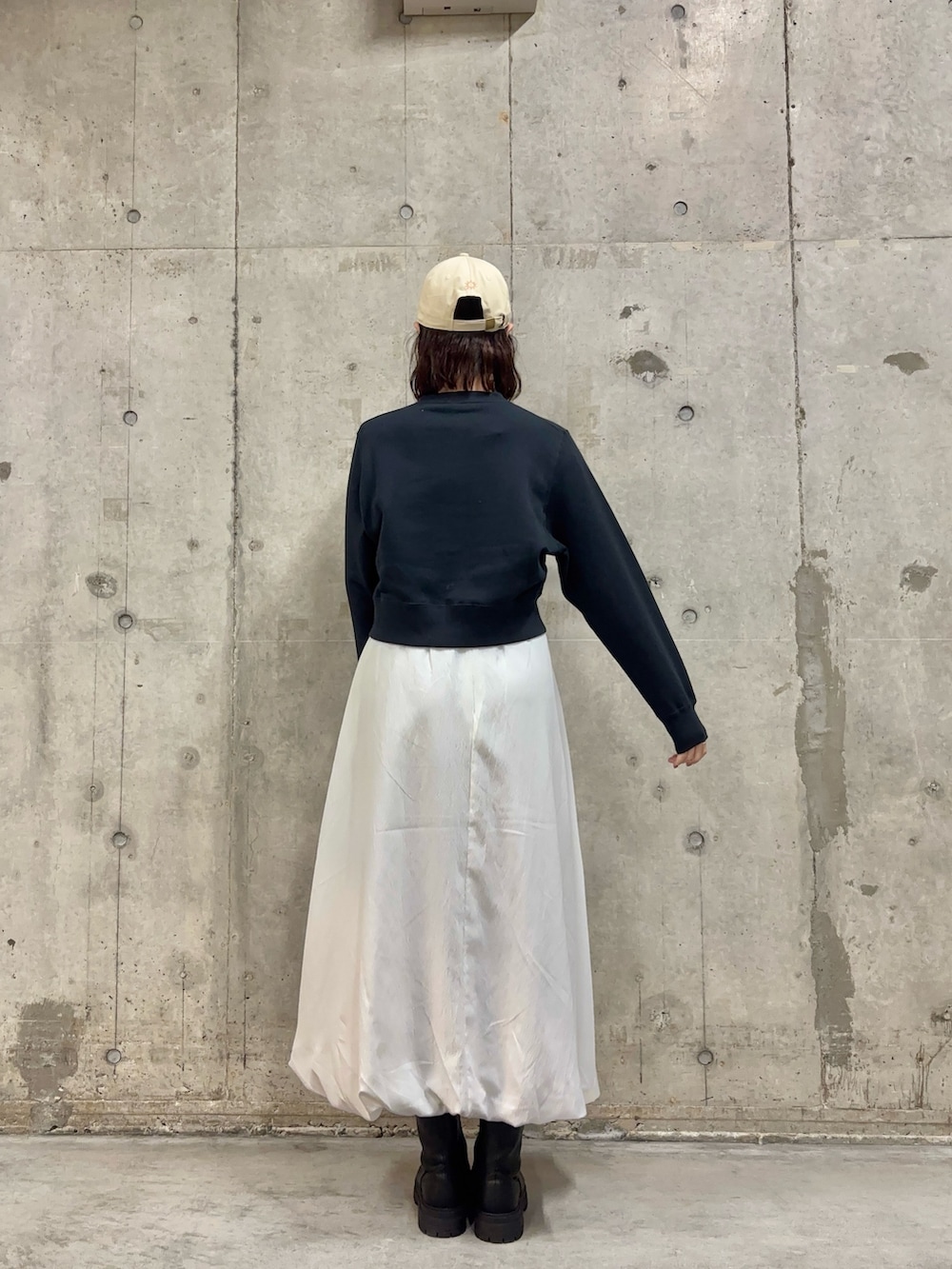 ブルー系のカーディガン/ボレロ、ブラック系のブーツ、ホワイト系のスカートを着用したレディースの冬コーディネートの4枚目の写真