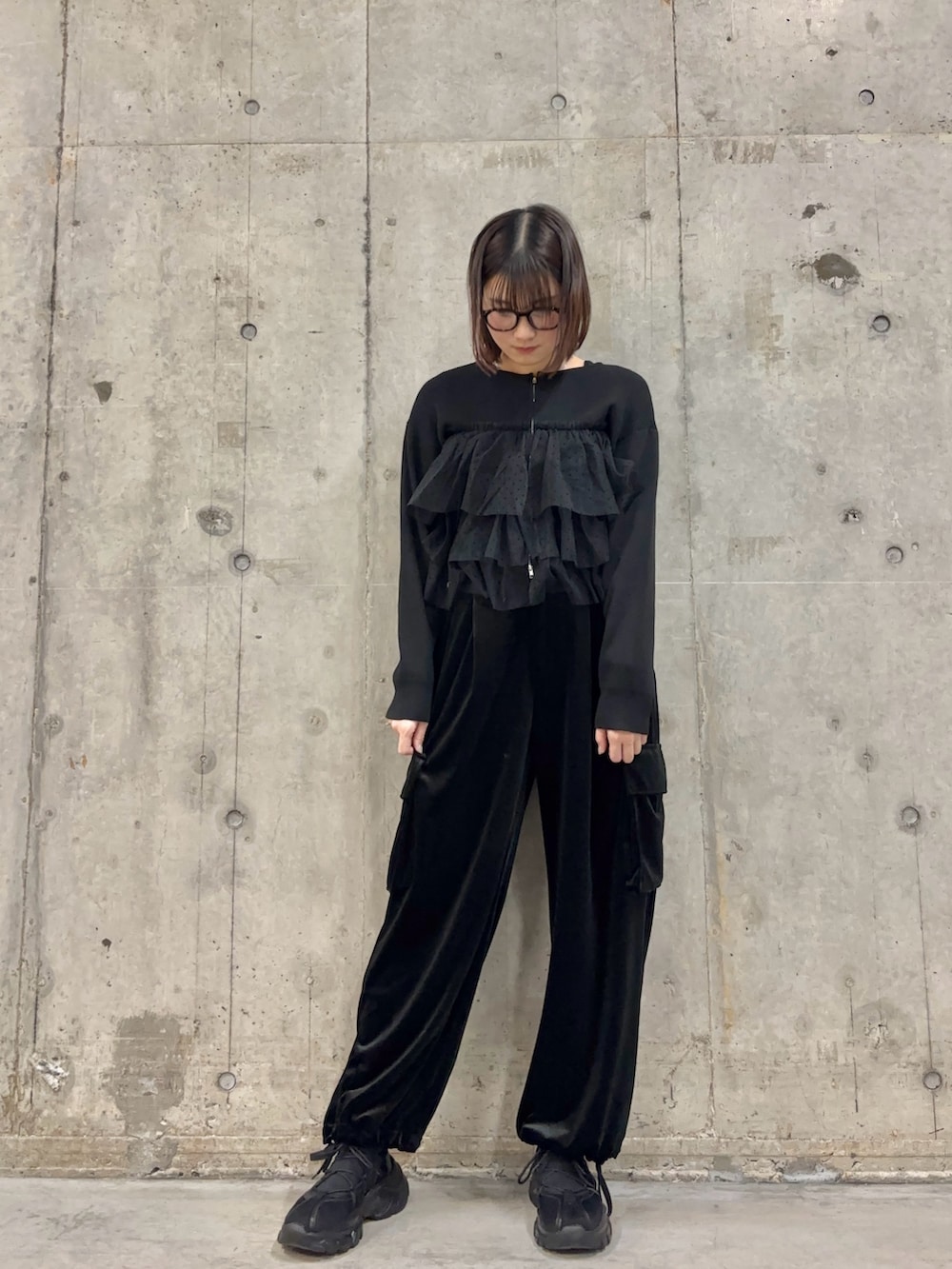 ブラック系のその他パンツ、ブラック系のニット/セーター、ブラック系のスニーカーを着用したレディースの冬コーディネートの2枚目の写真