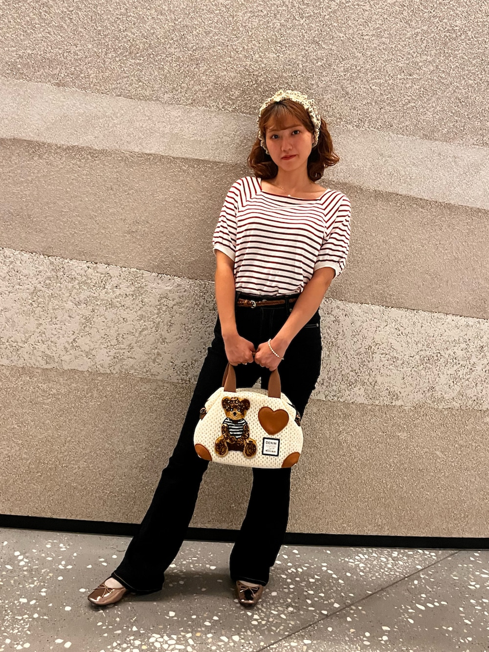 レッド系のTシャツ/カットソー、ゴールド系のバレエシューズ、ブルー系のデニムパンツを着用したレディースの秋コーディネートの2枚目の写真