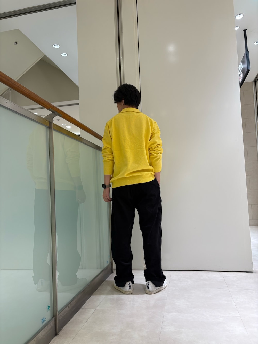 イエロー系のニット/セーター、ブラック系のパンツを着用したメンズの秋コーディネートの3枚目の写真