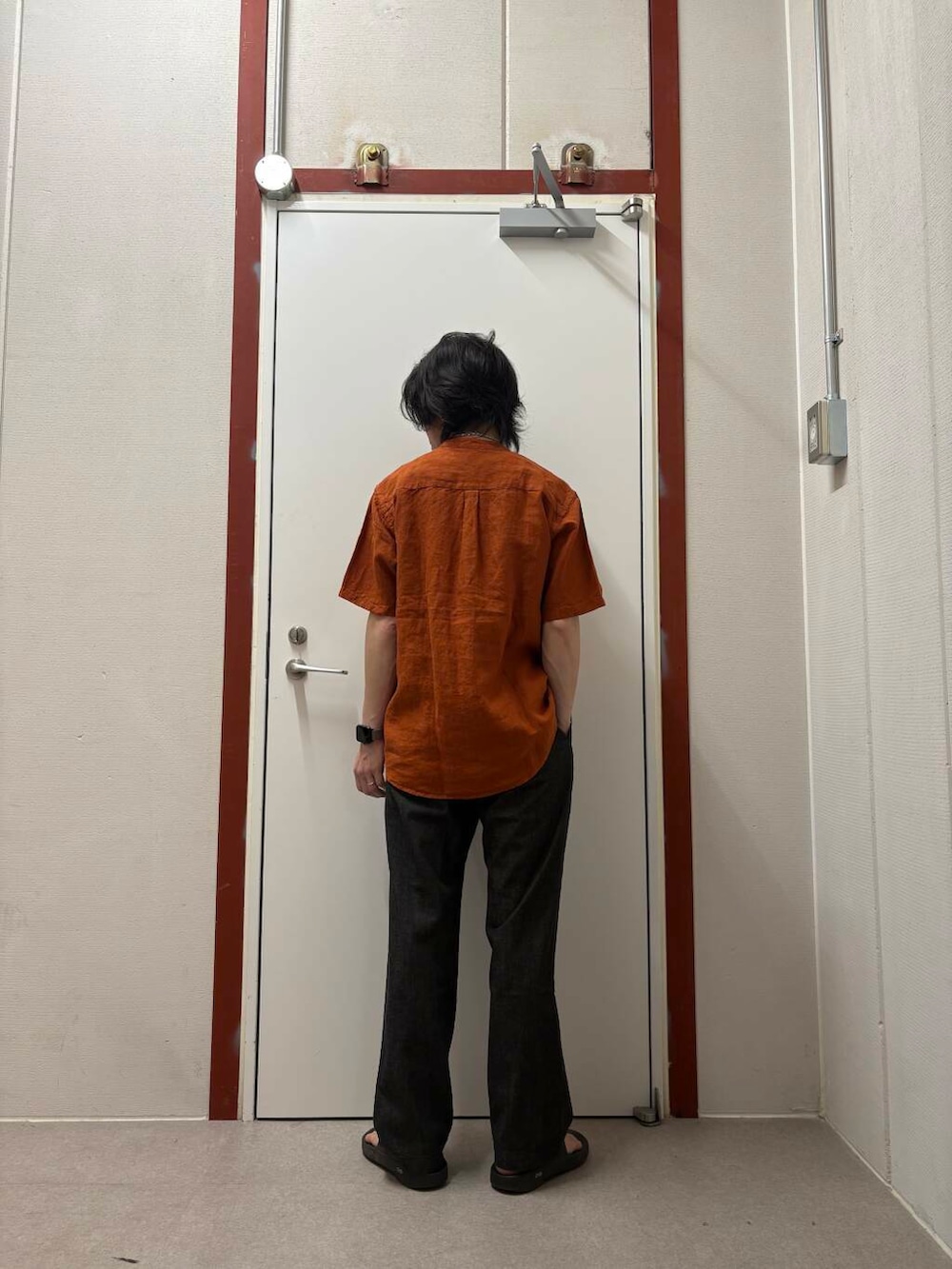 オレンジ系のシャツ/ブラウス、ブラック系のサンダル、ブラック系のデニムパンツを着用したメンズの夏コーディネートの3枚目の写真