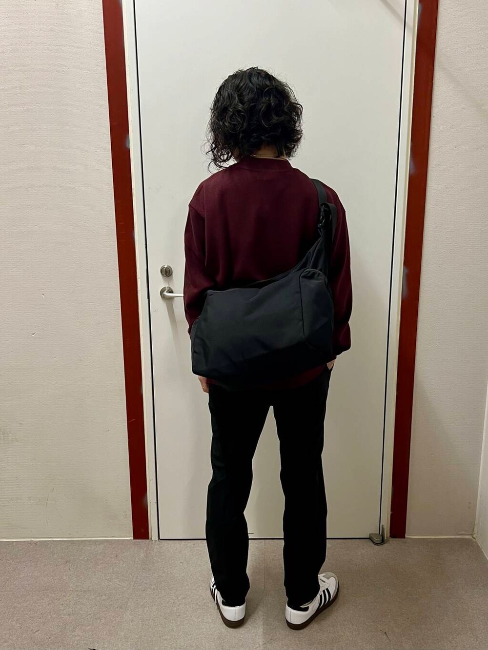 ブラック系のその他パンツ、ブラック系のショルダーバッグ、ホワイト系のスニーカーを着用したメンズの秋コーディネートの3枚目の写真