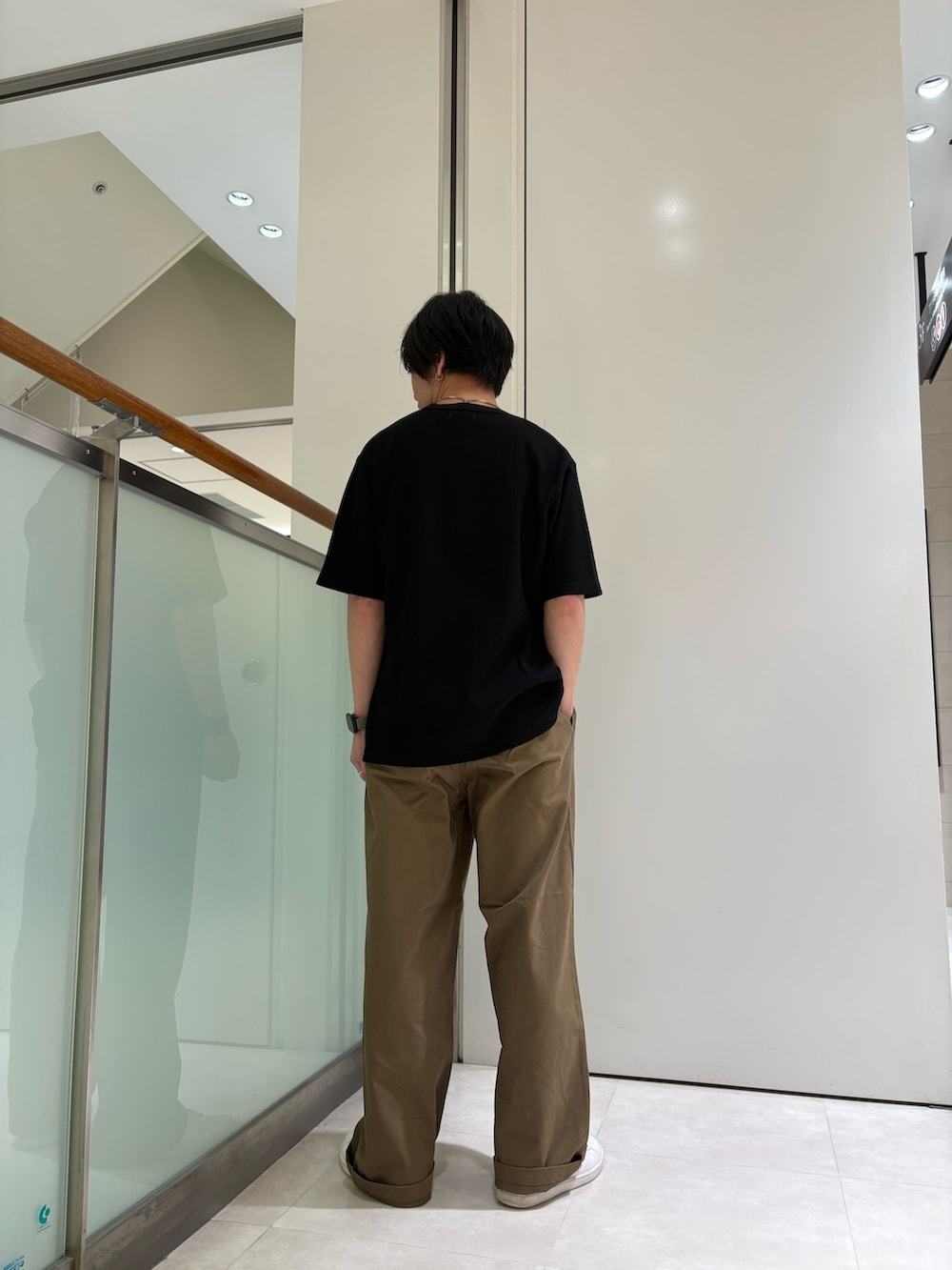 ブラック系のTシャツ/カットソー、ベージュ系のチノパンツを着用したメンズの夏コーディネートの3枚目の写真