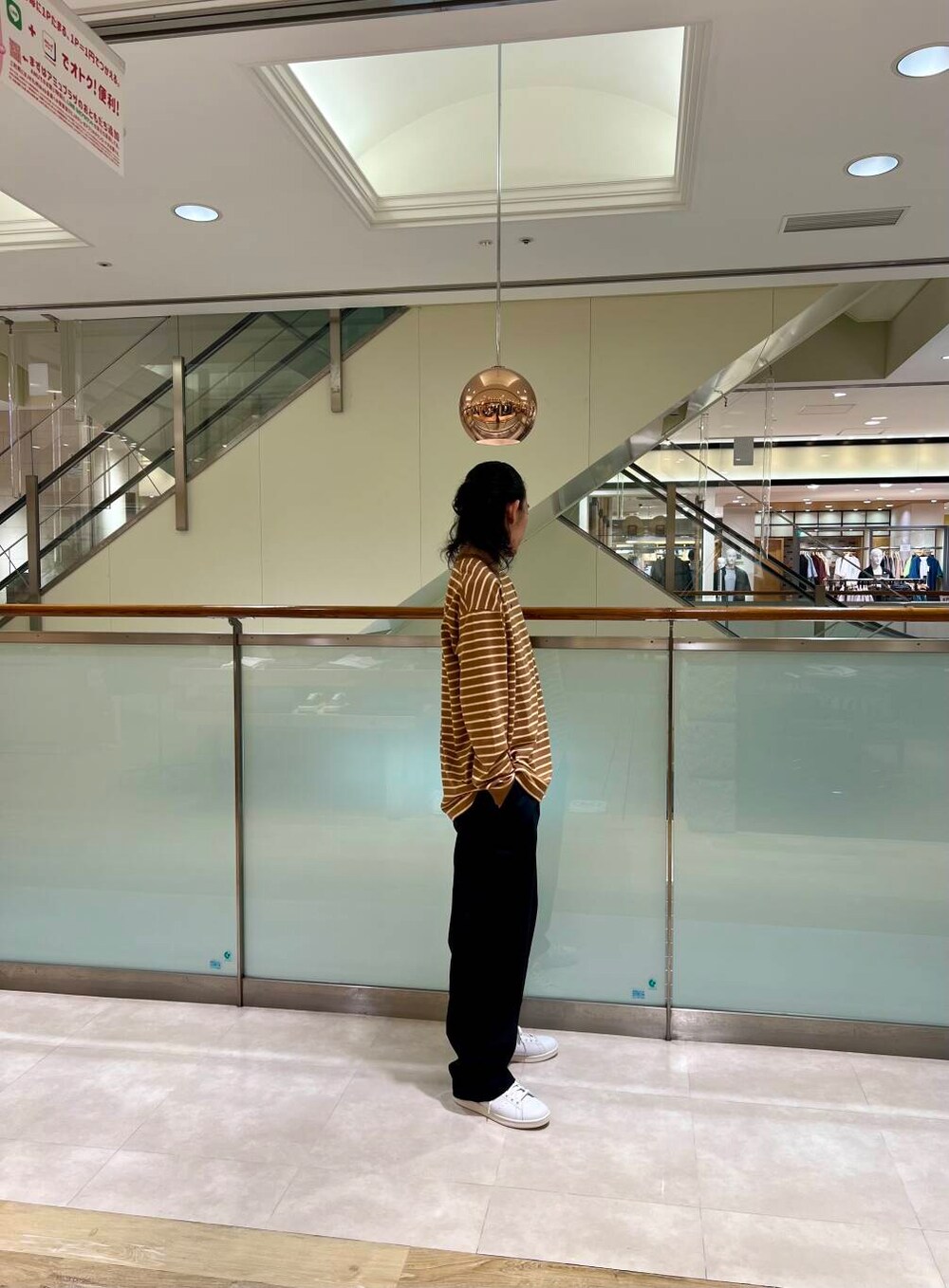 ホワイト系のスニーカー、ブラック系のチノパンツを着用したメンズの夏コーディネートの2枚目の写真