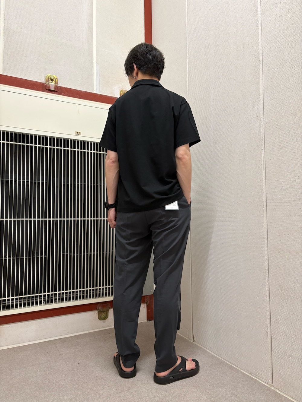 ブラック系のポロシャツ、グレー系のその他パンツを着用したメンズの夏コーディネートの3枚目の写真