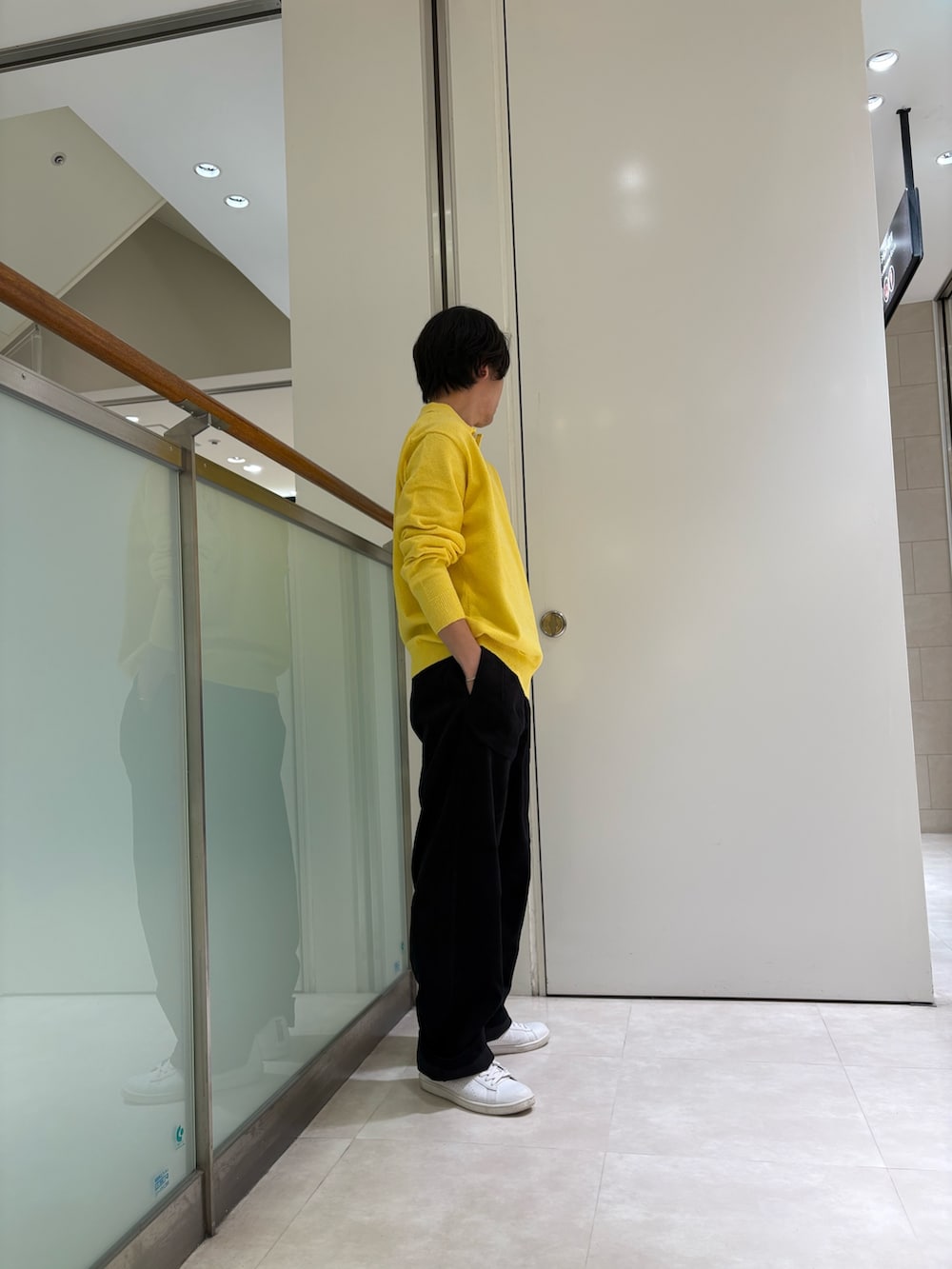 イエロー系のニット/セーター、ブラック系のパンツを着用したメンズの秋コーディネートの2枚目の写真
