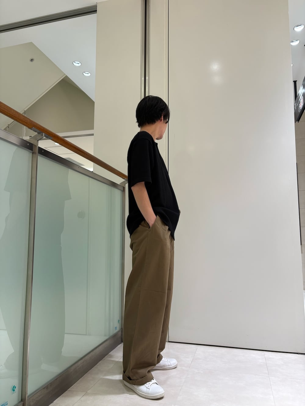 ブラック系のTシャツ/カットソー、ベージュ系のチノパンツを着用したメンズの夏コーディネートの2枚目の写真
