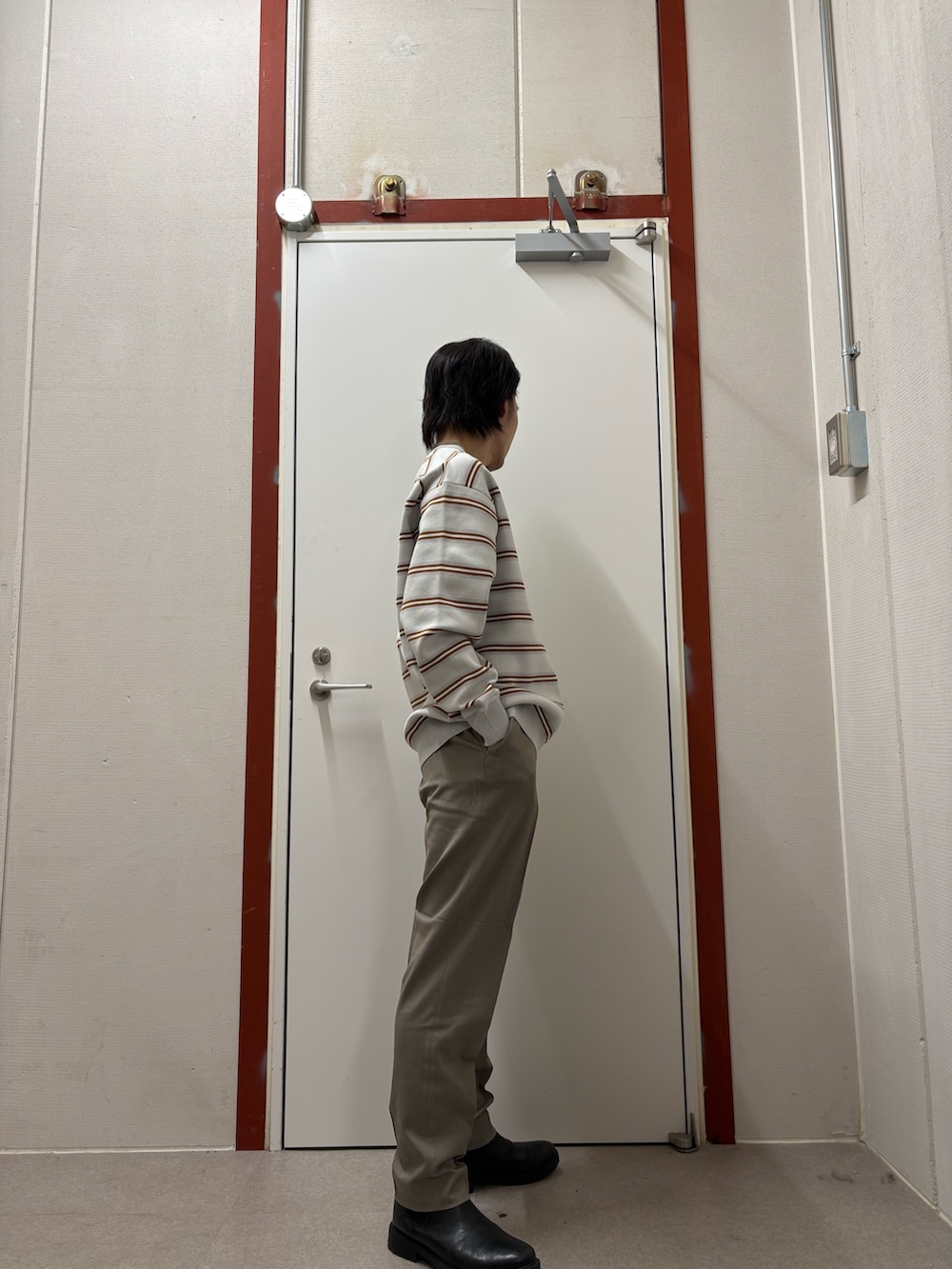 グレー系のニット/セーター、ベージュ系のその他パンツを着用したメンズの冬コーディネートの2枚目の写真