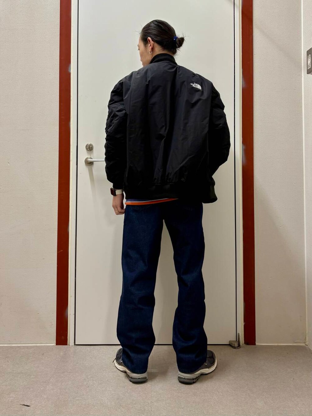 ブルー系のデニムパンツ、パープル系のスウェット、グレー系のスニーカーを着用したメンズの秋コーディネートの3枚目の写真