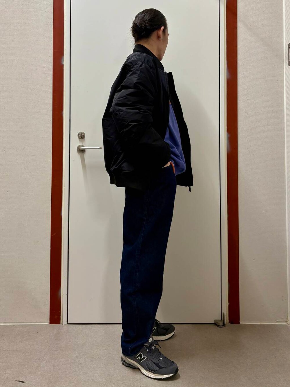 ブルー系のデニムパンツ、パープル系のスウェット、グレー系のスニーカーを着用したメンズの秋コーディネートの2枚目の写真