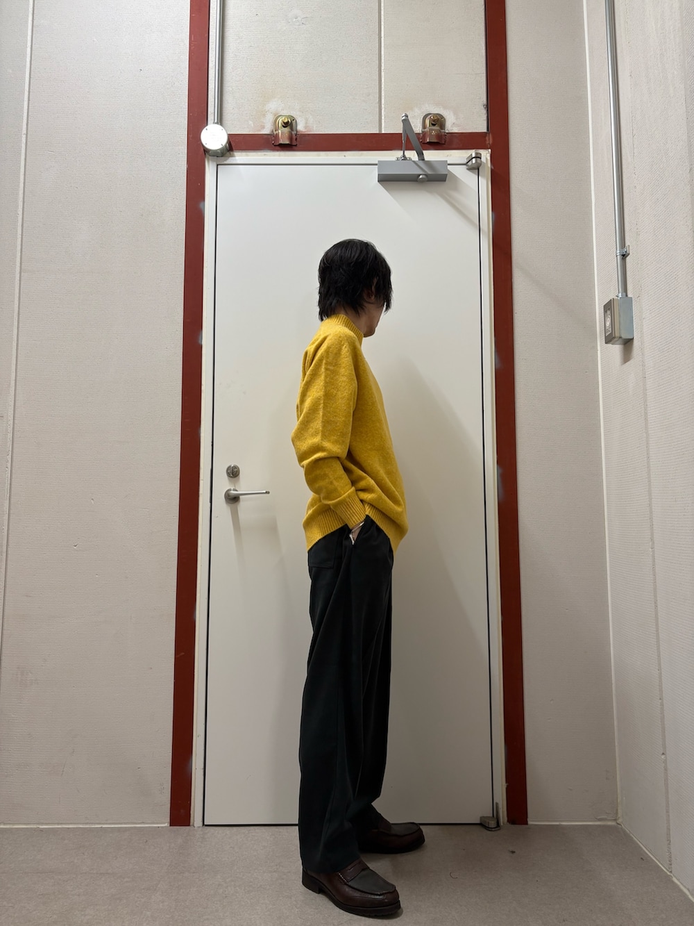 イエロー系のニット/セーター、ブラック系のその他パンツを着用したメンズの秋コーディネートの2枚目の写真