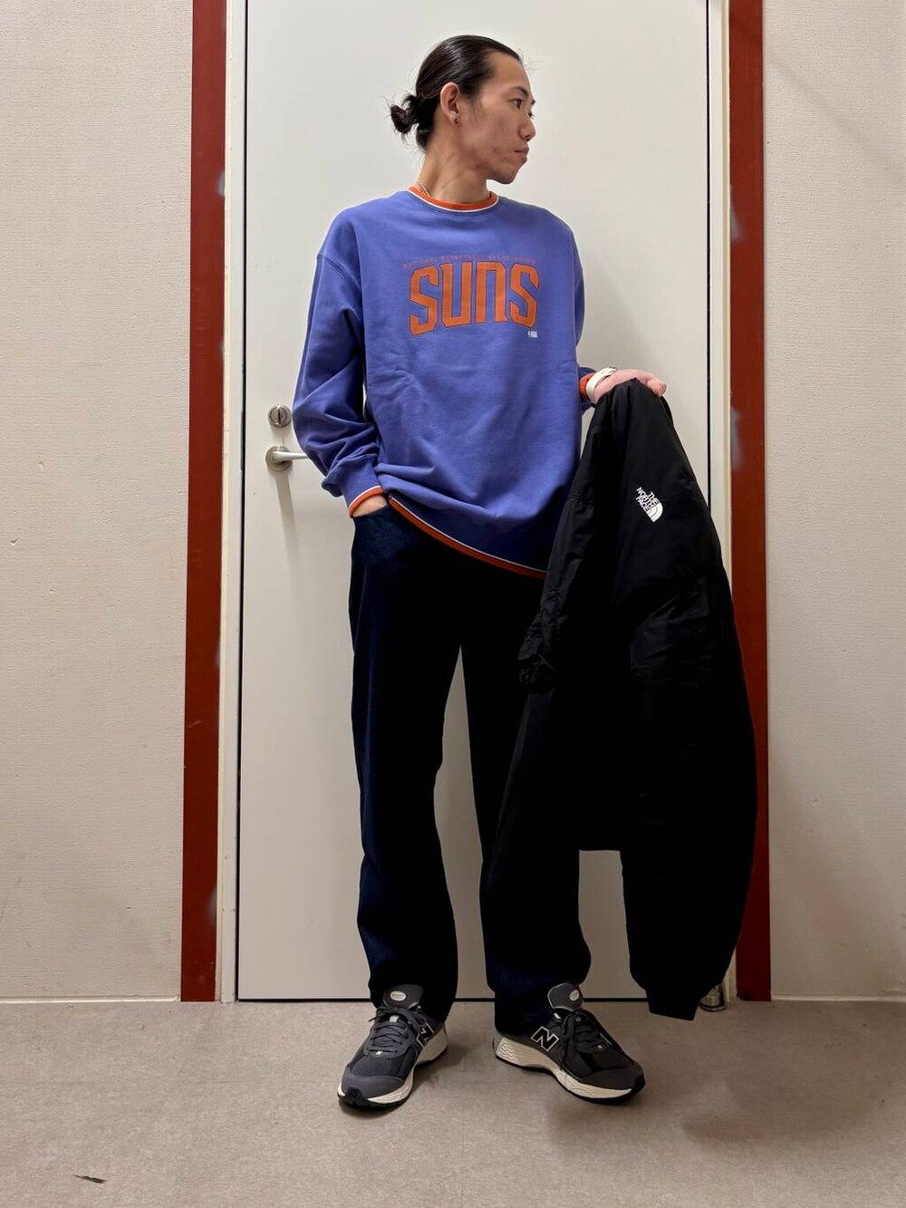 ブルー系のデニムパンツ、パープル系のスウェット、グレー系のスニーカーを着用したメンズの秋コーディネートの4枚目の写真