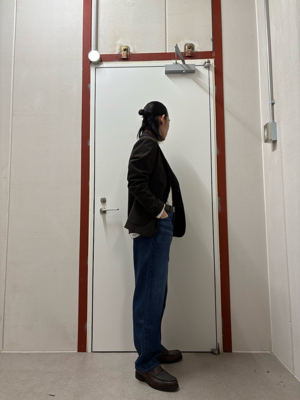 ブラウン系のスーツジャケット、ホワイト系のシャツ/ブラウス、ブルー系のデニムパンツを着用したメンズの秋コーディネートの2枚目の写真