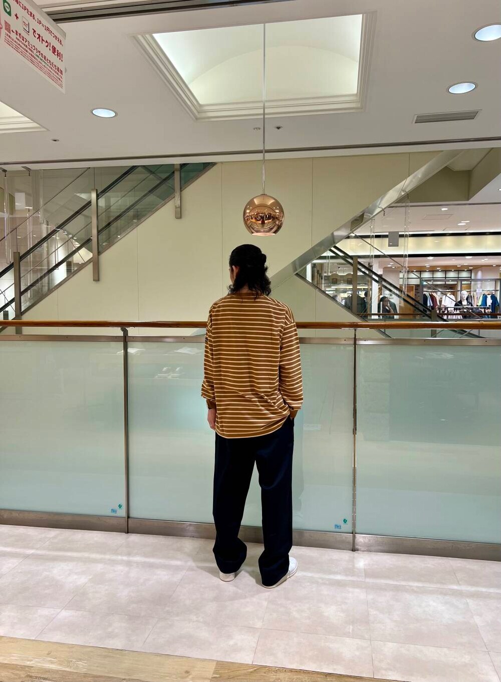 ホワイト系のスニーカー、ブラック系のチノパンツを着用したメンズの夏コーディネートの3枚目の写真