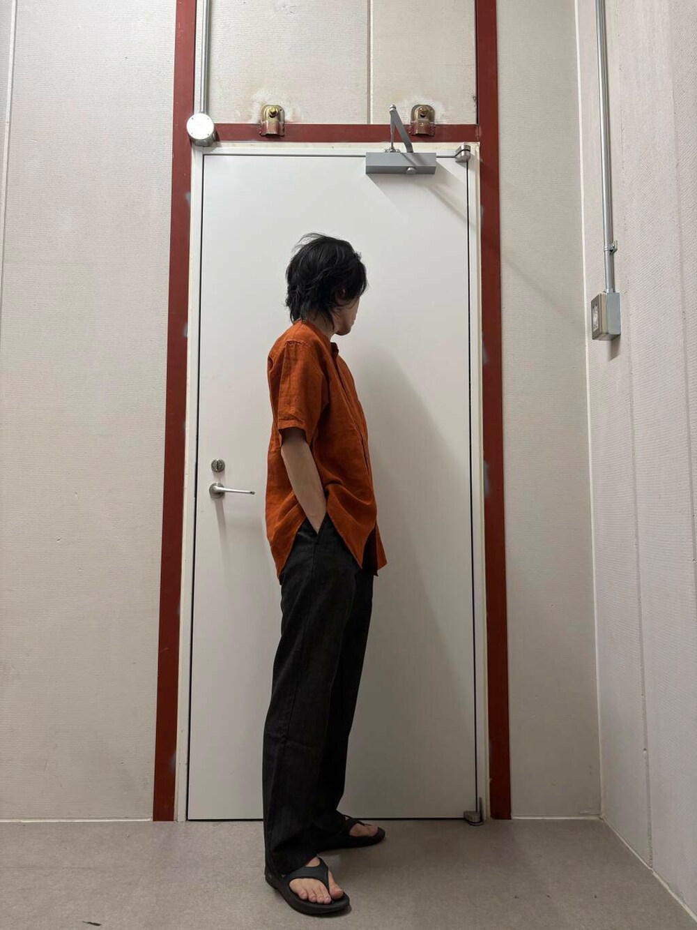 オレンジ系のシャツ/ブラウス、ブラック系のサンダル、ブラック系のデニムパンツを着用したメンズの夏コーディネートの2枚目の写真