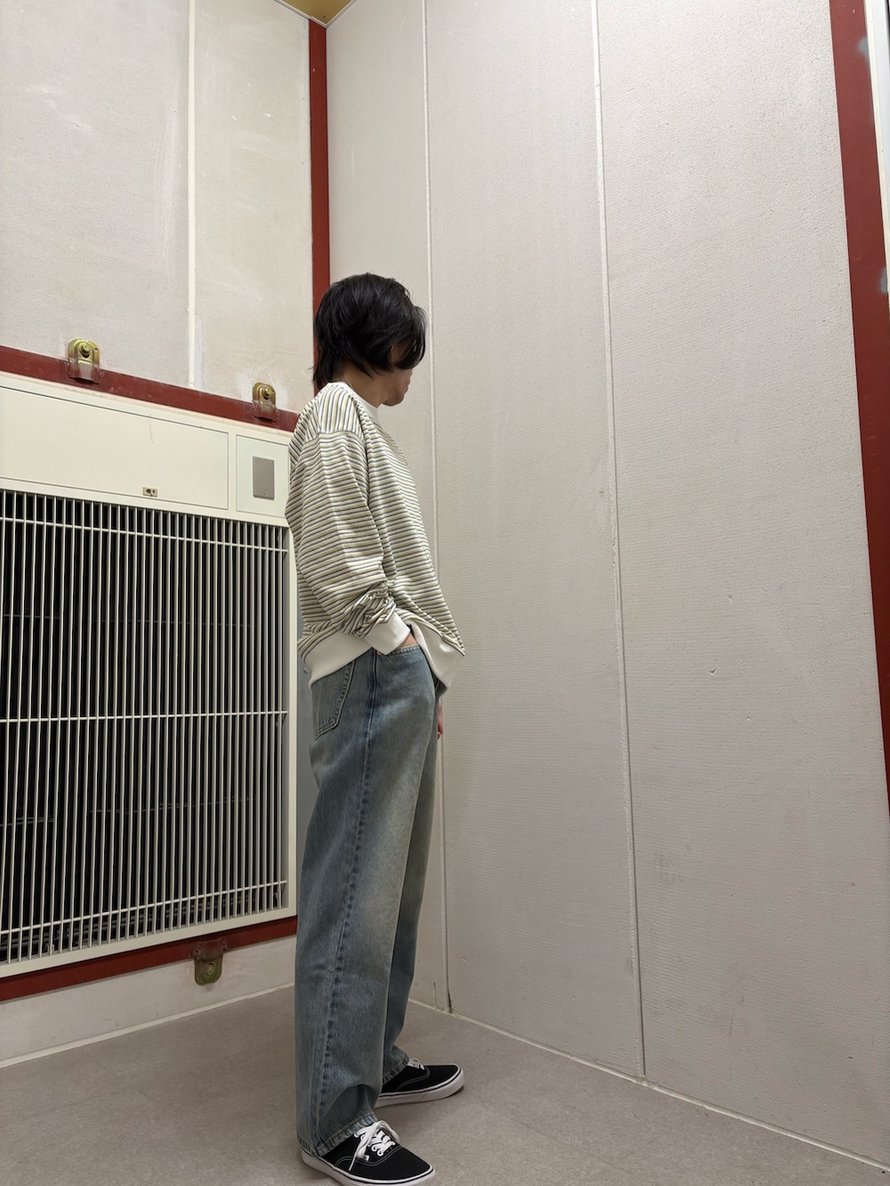 イエロー系のTシャツ/カットソー、ブルー系のデニムパンツを着用したメンズの冬コーディネートの2枚目の写真