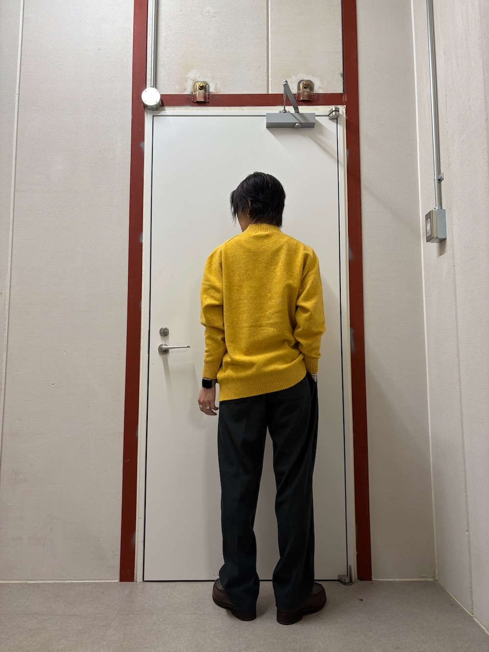 イエロー系のニット/セーター、ブラック系のその他パンツを着用したメンズの秋コーディネートの3枚目の写真