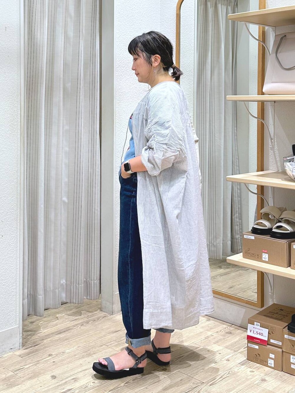 ブラック系のワンピース、ベージュ系のショルダーバッグ、グレー系のサンダルを着用したレディースの夏コーディネートの6枚目の写真