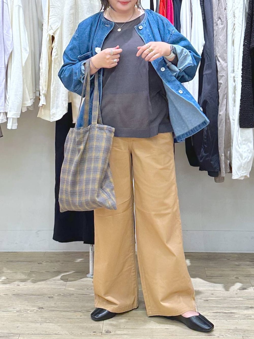 ベージュ系のチノパンツ、ブルー系のノーカラージャケット、ブラウン系のタンクトップを着用したレディースの秋コーディネートの6枚目の写真