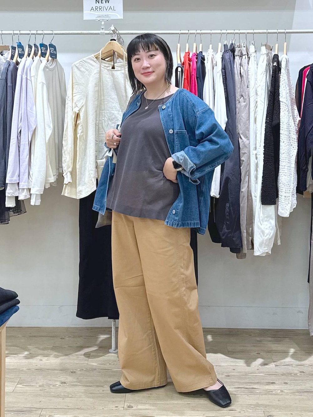 ベージュ系のチノパンツ、ブルー系のノーカラージャケット、ブラウン系のタンクトップを着用したレディースの秋コーディネートの5枚目の写真